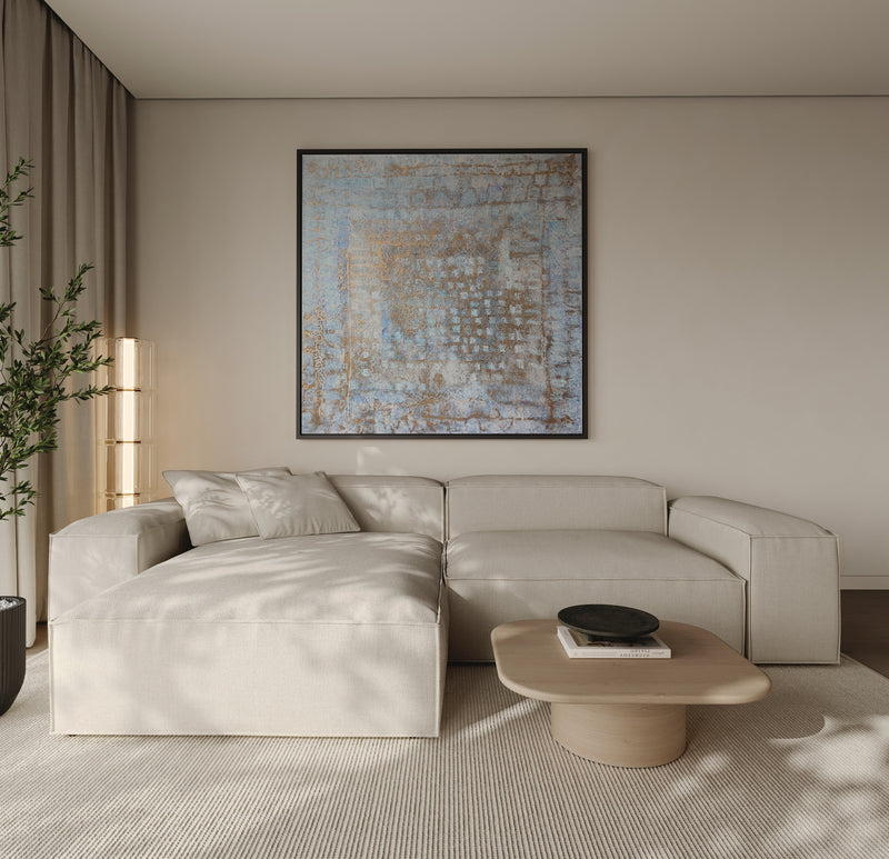 Modern living room with a beige sectional sofa, coffee table, and abstract art on the wall.