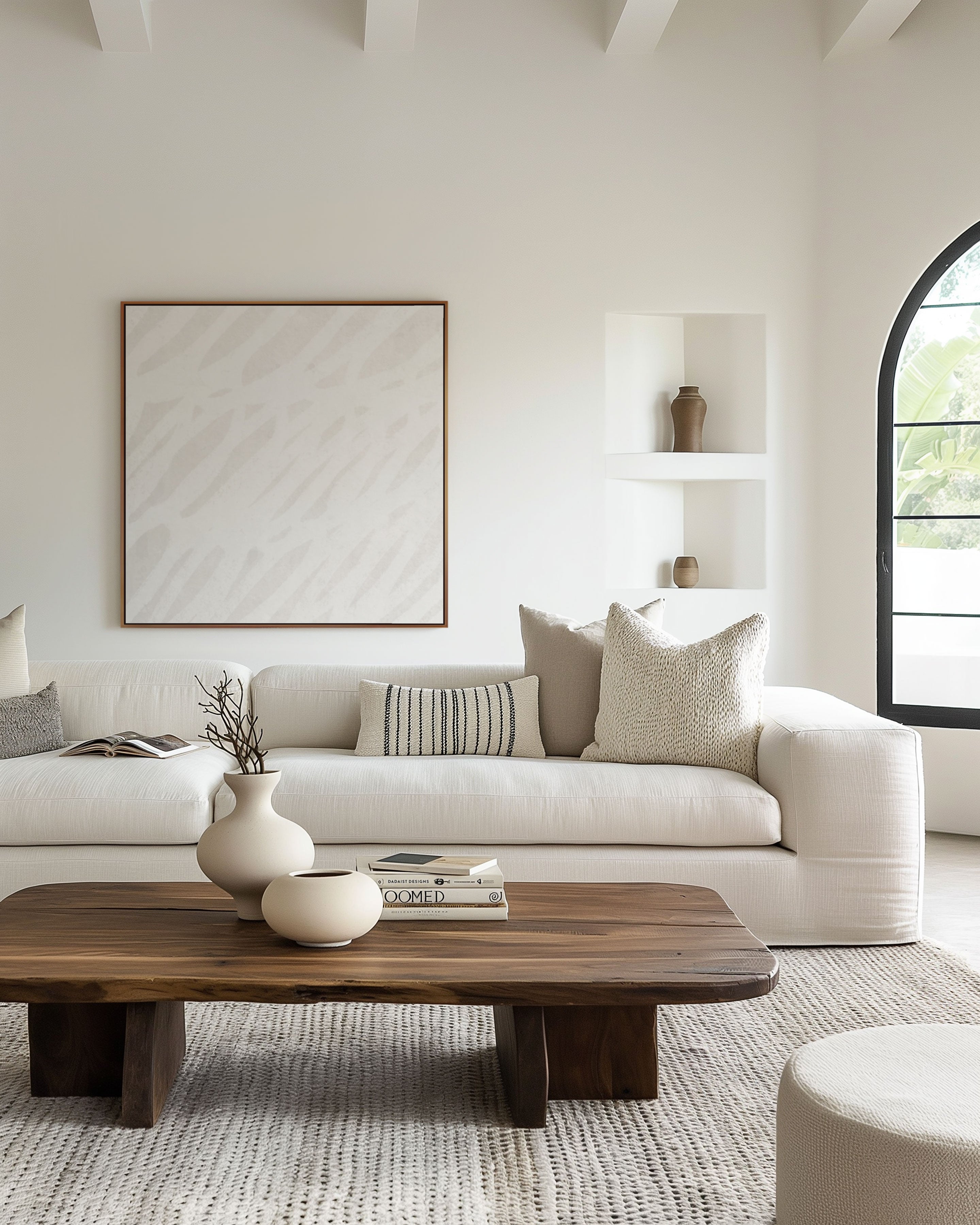 White on white neutral abstract expressionist framed wall art print in a white neutral minimalist room with warm wood accents and textured pillows. Modern quiet luxury. Art Collectiv wholesale program for interior designers and retailers.